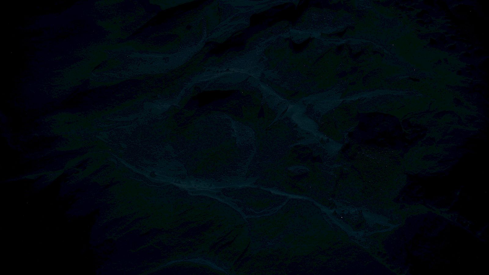 The image appears to be a dark, abstract or aerial view of a landscape with swirling patterns and textures.
